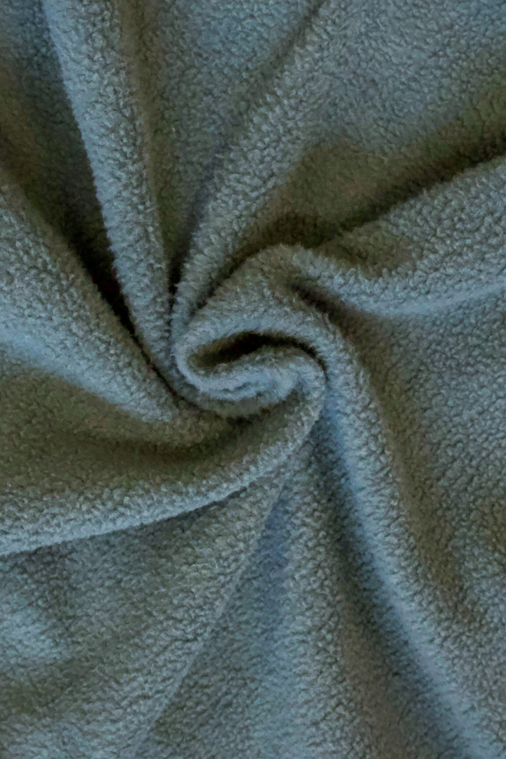 Close-up of a green crew neck sweatshirts fleece lined interior 