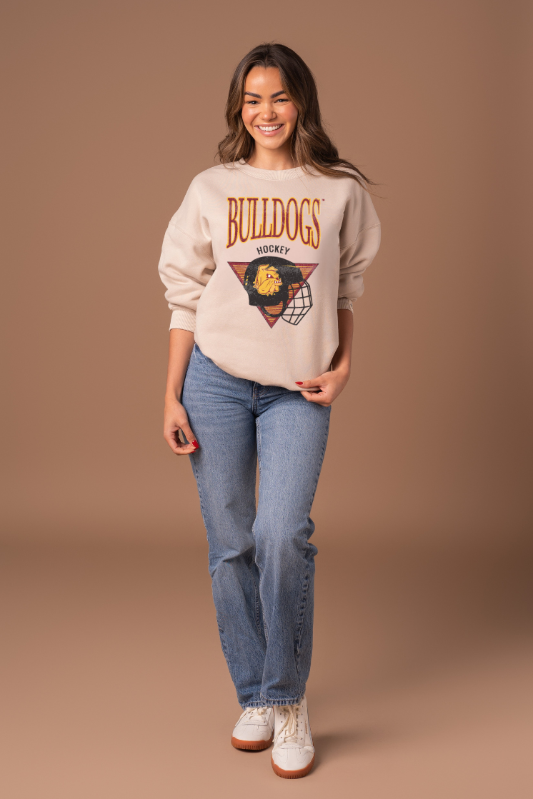Girl wearing a beige sweatshirt with 'Bulldogs Hockey' design on a brown background