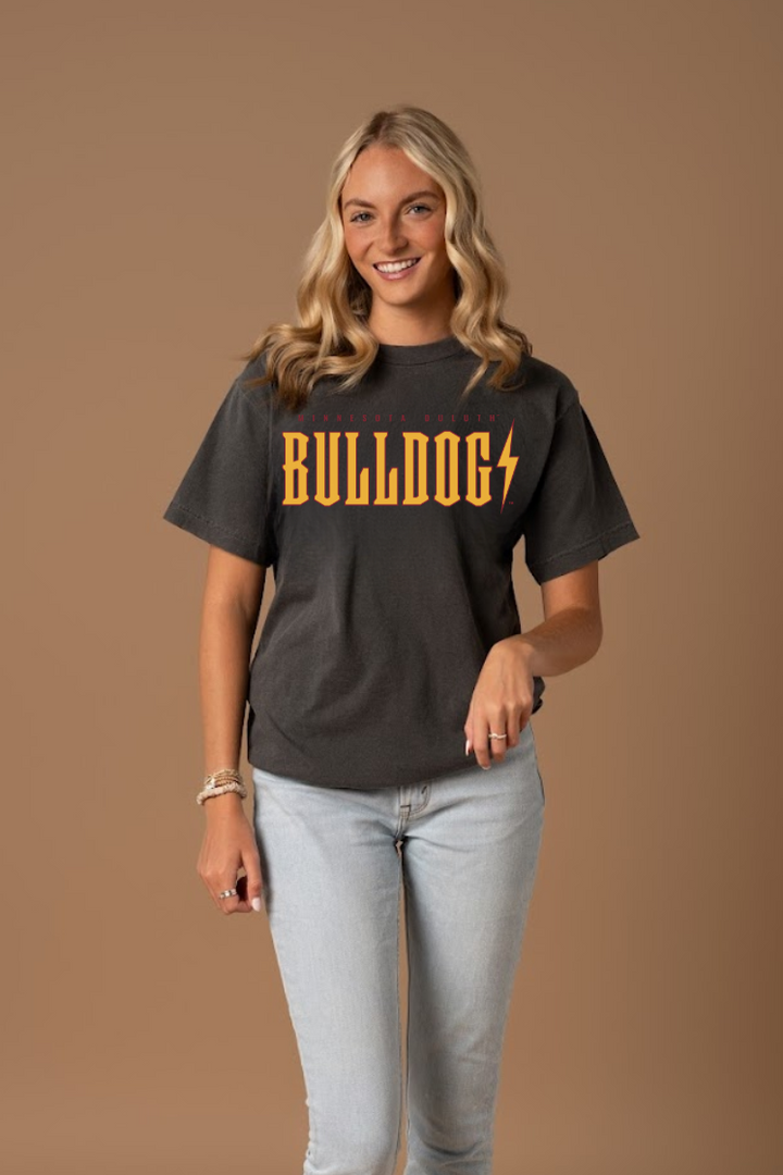 Close up picture of a woman wearing a ash grey t-shirt with 'Bulldogs' printed in yellow and maroon on a brown background