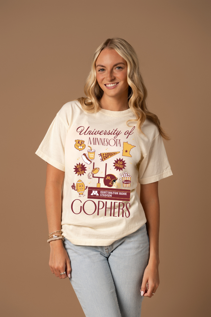 Woman wearing a 'University of Minnesota Gophers' t-shirt against a brown background